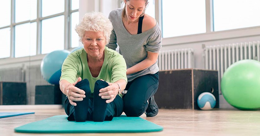 Elderly woman actively stretching and smiling